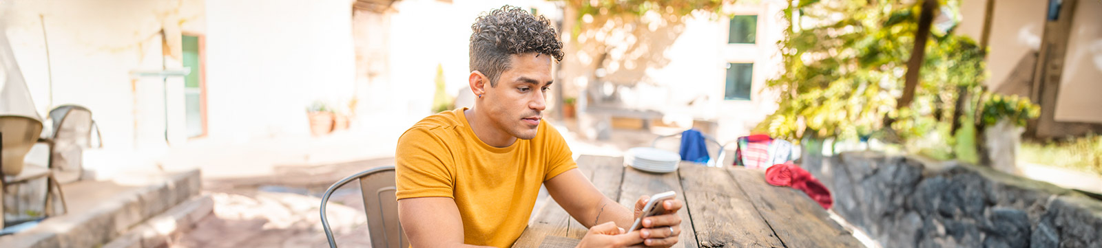 Young man using mobile phone at outdoor cafe